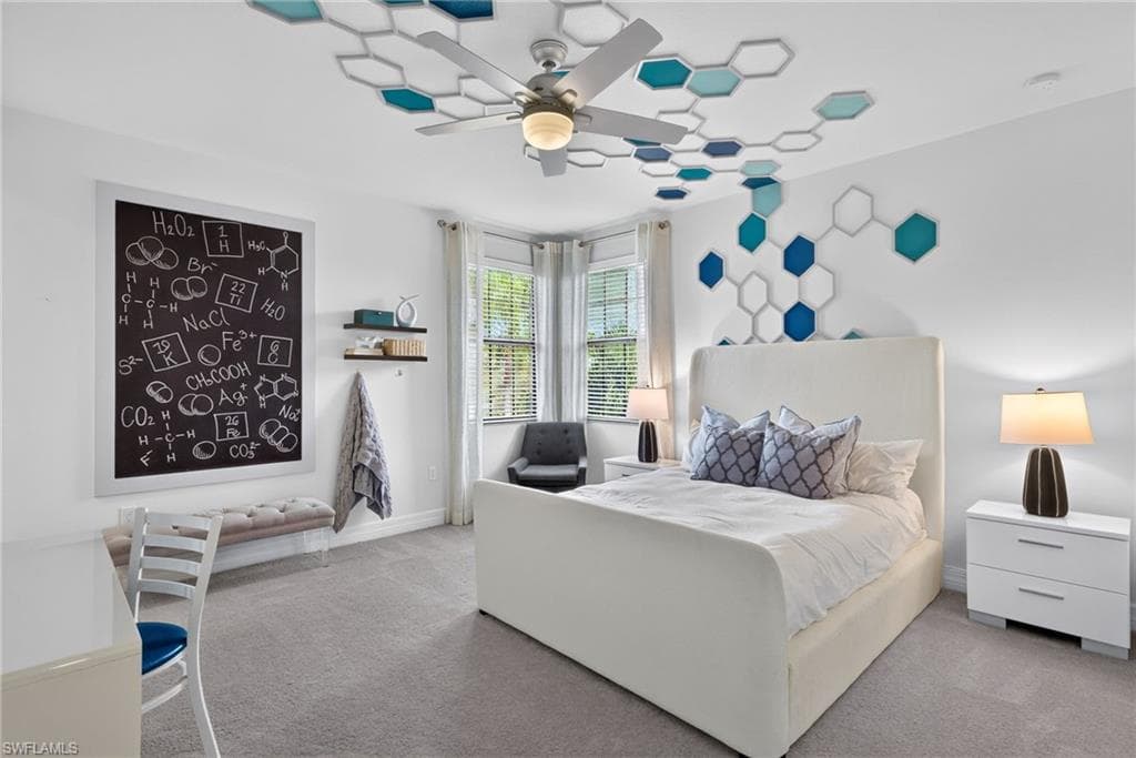 4th bedroom, with ensuite bathroom. Ceiling fan with light fixture, decorative ceiling and wall accents, corner windows with blinds, and built-in chalkboard