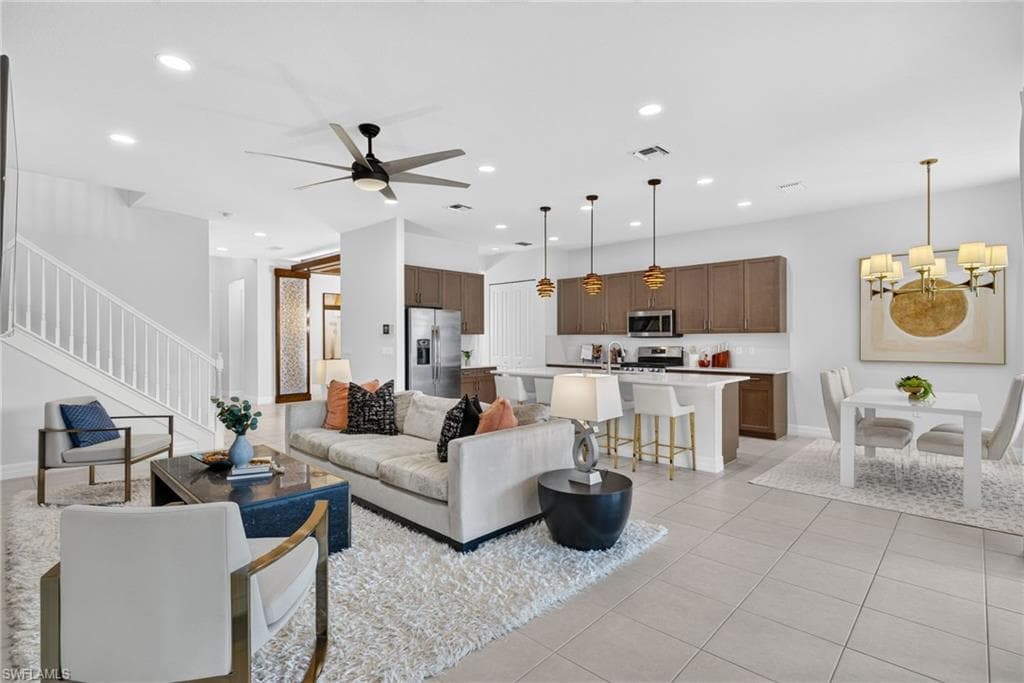 Open-concept living area featuring a ceiling fan with integrated lighting, recessed lighting, and tile flooring