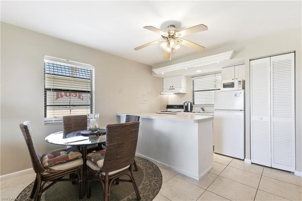 Dining room with sink, ceiling fan, and light tile floors