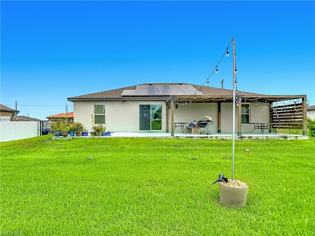 Expansive green lawn with a white privacy fence