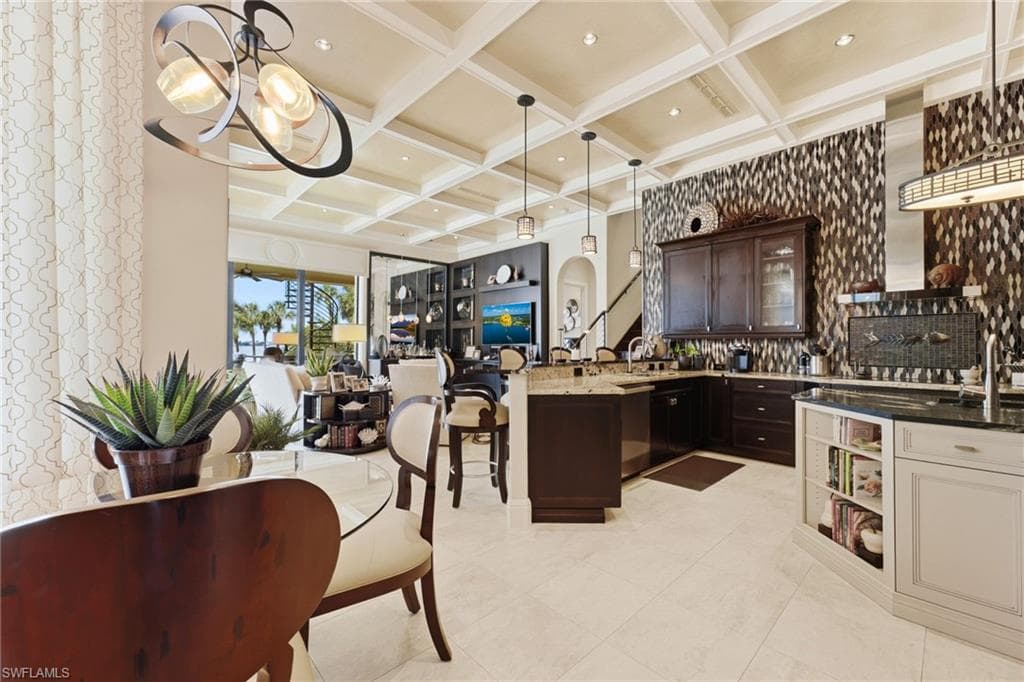 The kitchen is truly one of a kind, featuring an open-concept design, premium Wolf and Sub-Zero appliances, a dramatic floor-to-ceiling backsplash, and exquisite marble and granite countertops. Designed for both culinary excellence and effortless entertaining, it flows seamlessly into a charming breakfast area, where spectacular views of the pool and river provide an extraordinary backdrop.