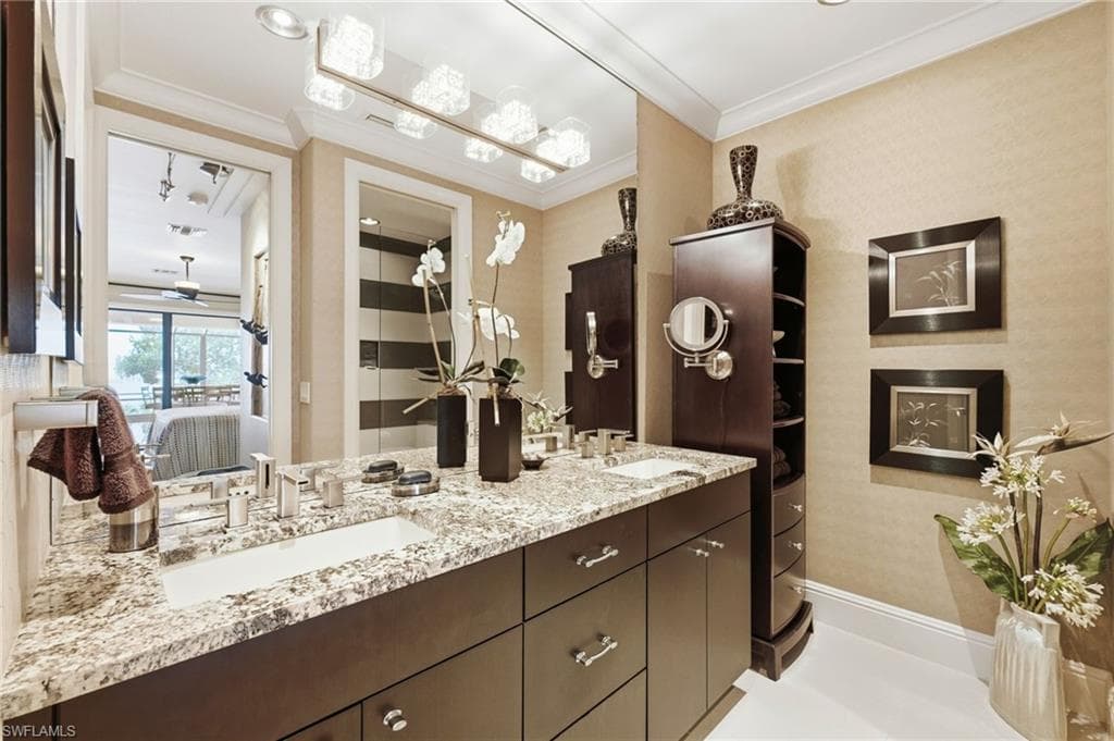 The fifth ensuite bath showcases refined elegance with dual granite countertops, custom wood cabinetry, and a private water closet. The walk-in shower features a unique Listello accent, adding a distinctive designer touch to this luxurious retreat.