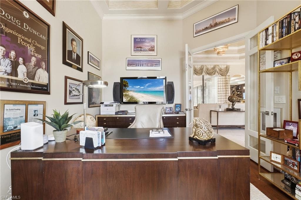 The private office offers a sophisticated workspace with elegant glass French doors, a beautifully detailed coffered ceiling, and an abundance of natural light creating an inspiring and refined atmosphere.
