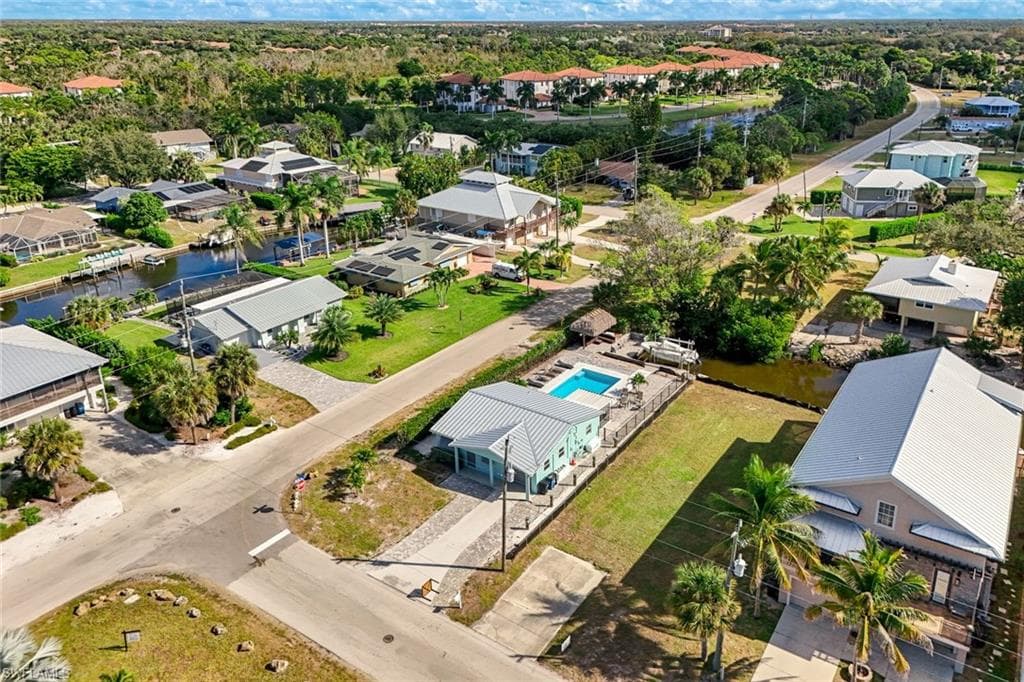 Aerial view of residential area with a nearby body of water and a pool area