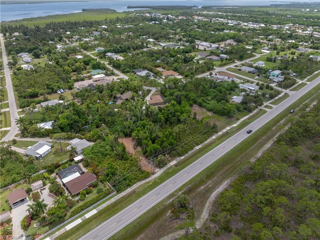 Aerial view showcasing a sprawling residential property nestled within mature landscaping and tree coverage