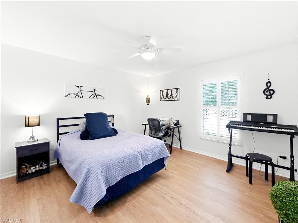 Wood-finish flooring with white walls and a ceiling fan