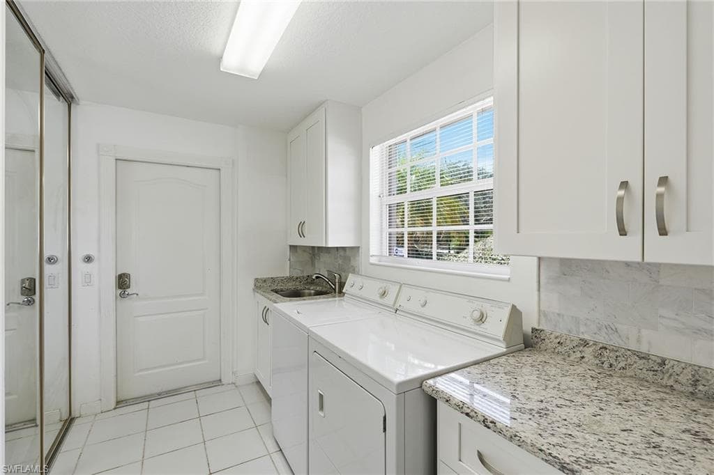 Spacious laundry room right off garage with sink and plenty of storage