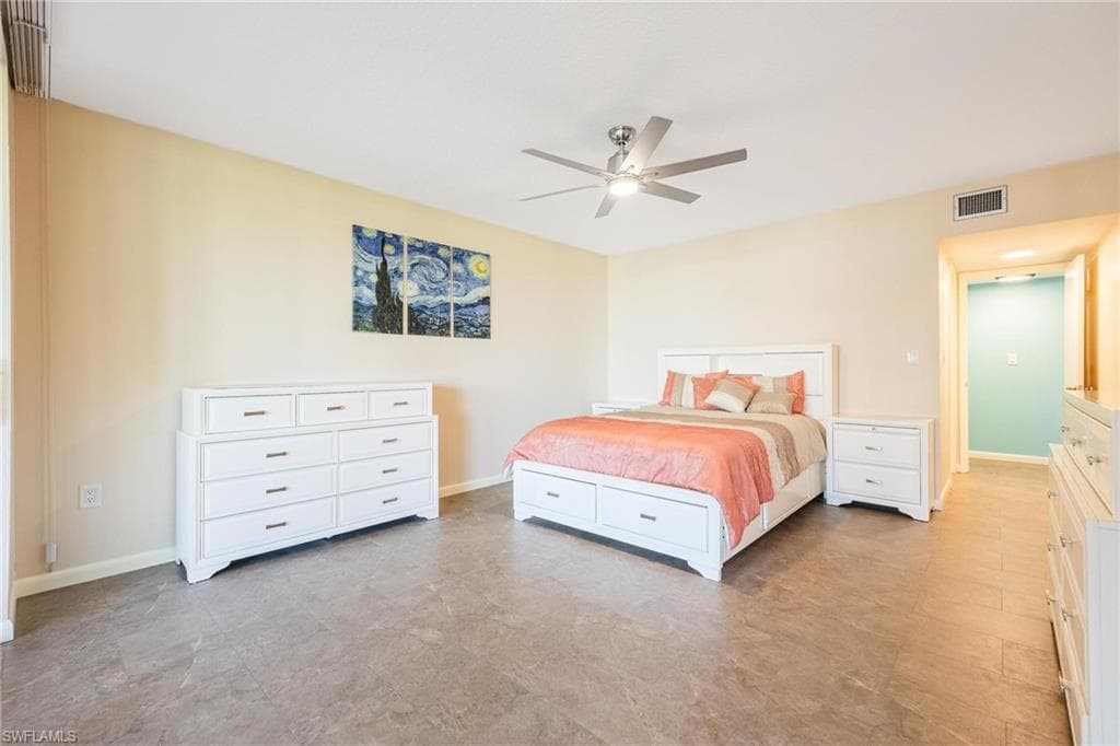 Spacious room featuring neutral wall tones, durable wood-finish flooring, and a ceiling fan with integrated lighting