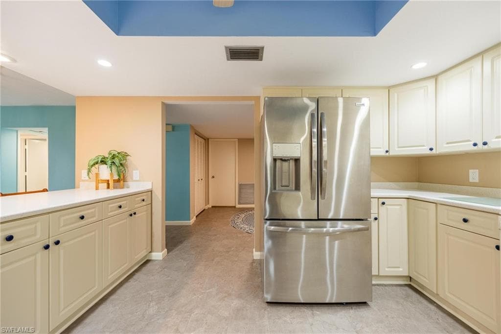 Kitchen featuring beige cabinetry, light countertops, and a stainless steel French door refrigerator