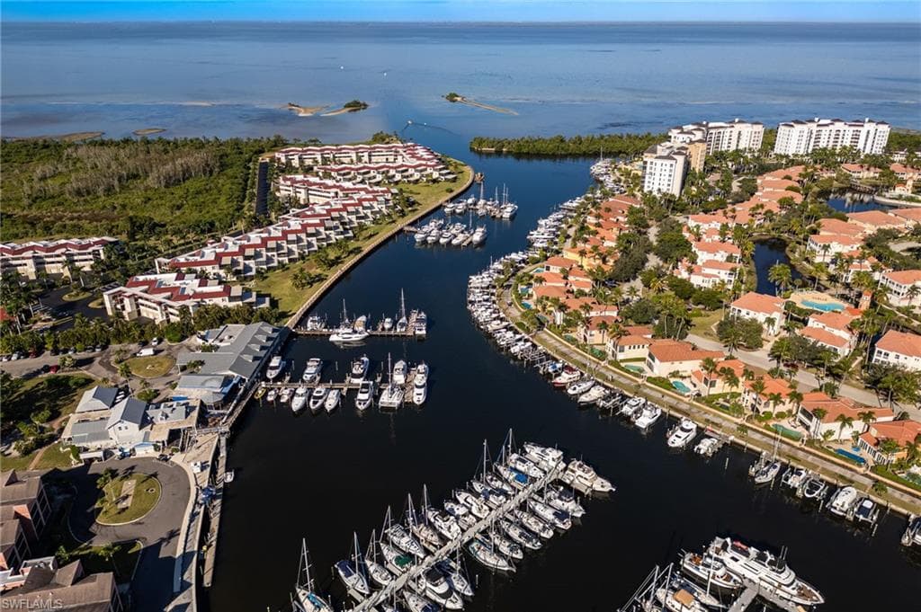 Aerial perspective showcasing a marina with numerous boats, bordered by residential properties and open water