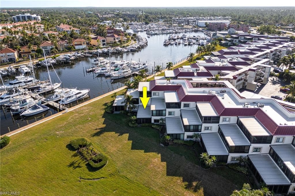 Waterfront condominium unit featuring a private balcony and direct access to a marina with multiple boat slips