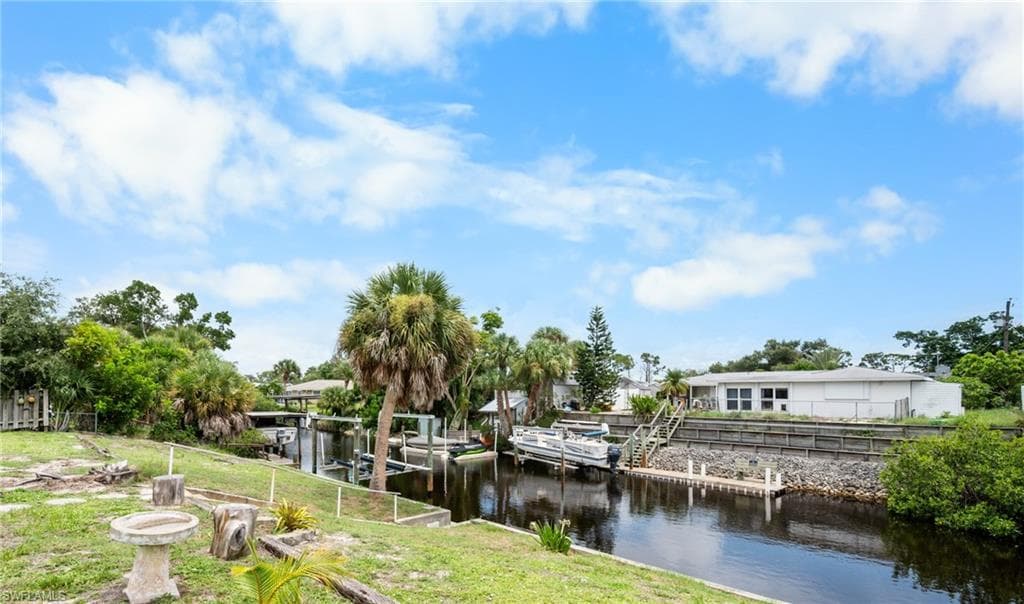Waterfront property featuring a canal, private dock, and a boat lift