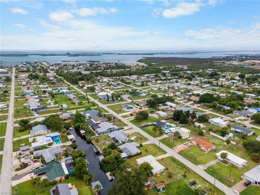 Residential community featuring canal-front properties and a large body of water in the background