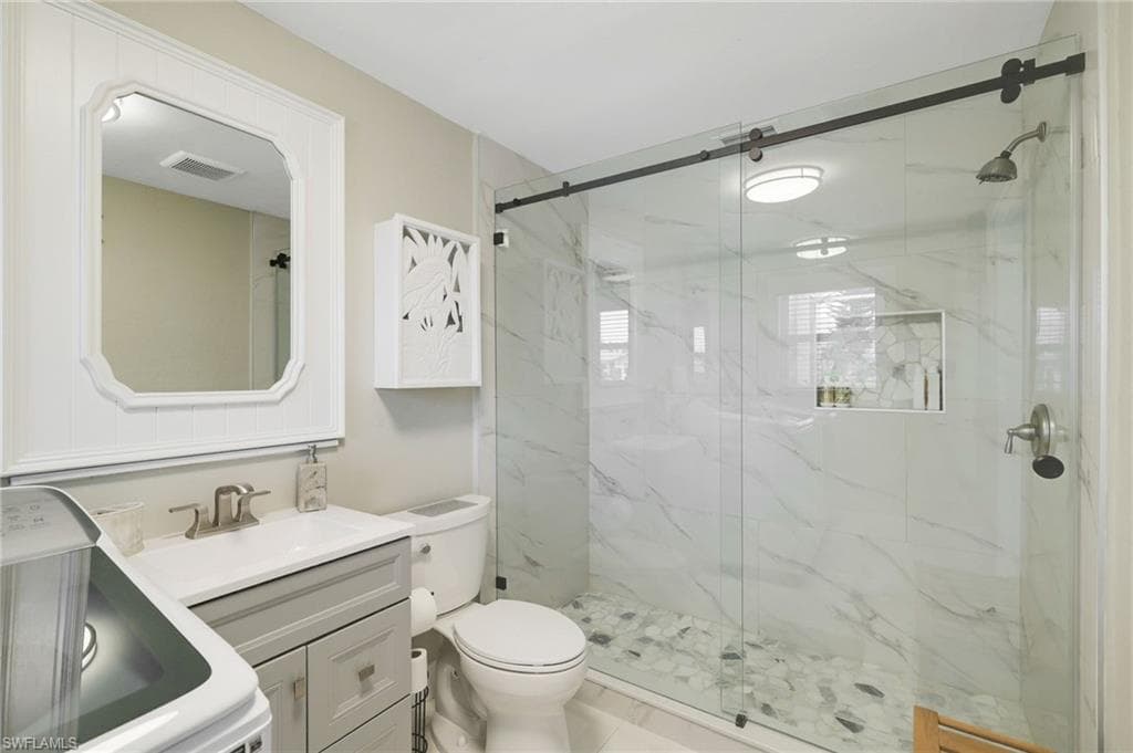 Walk-in shower with a glass enclosure and pebble flooring