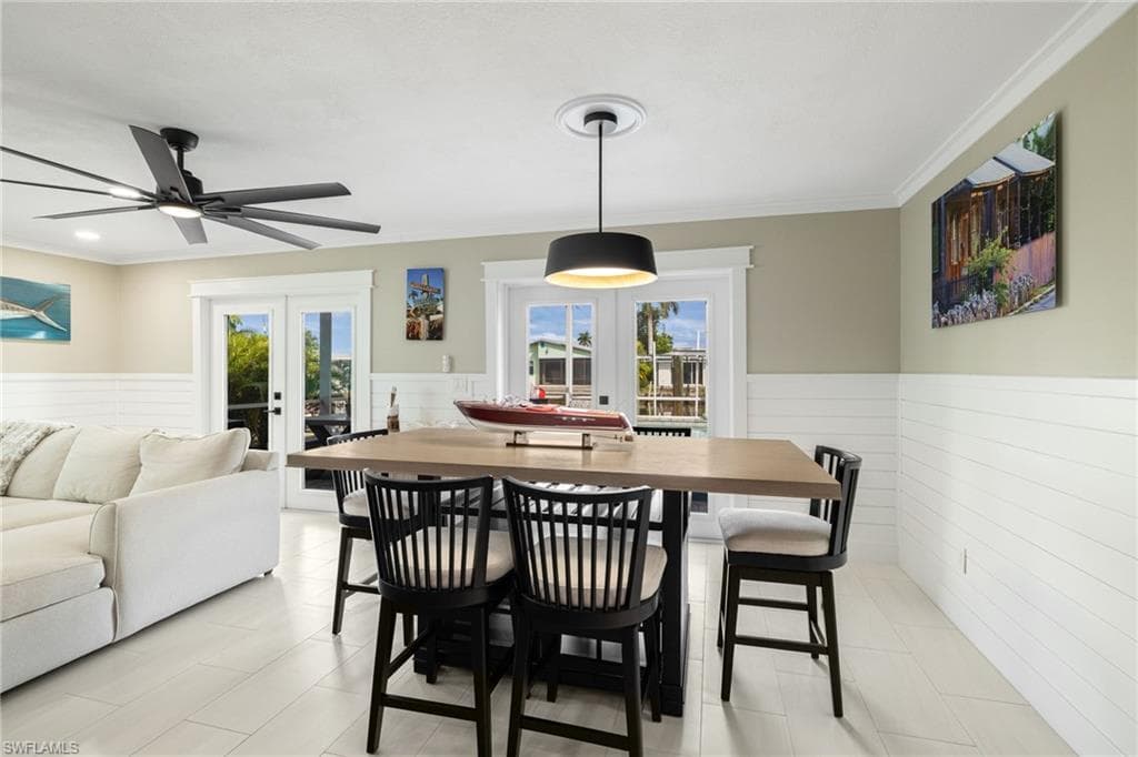 White wood-finish flooring, white shiplap wainscoting, and crown molding