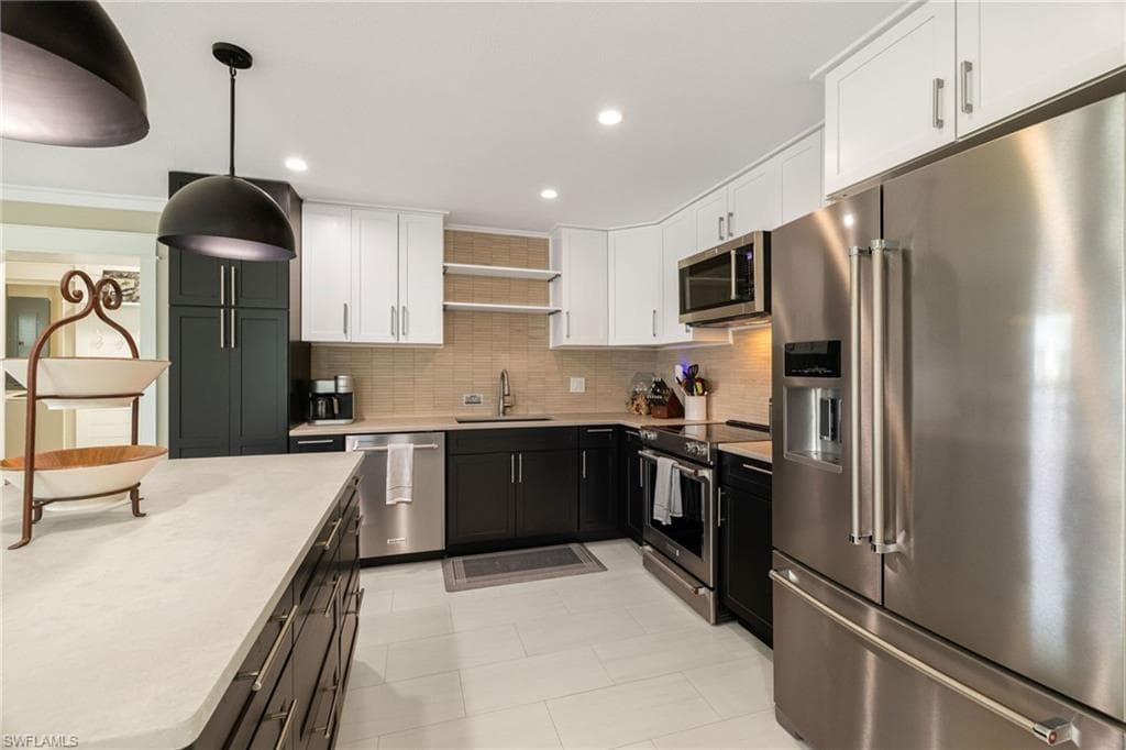 Kitchen featuring stainless steel appliances, recessed lighting, and a neutral tile backsplash