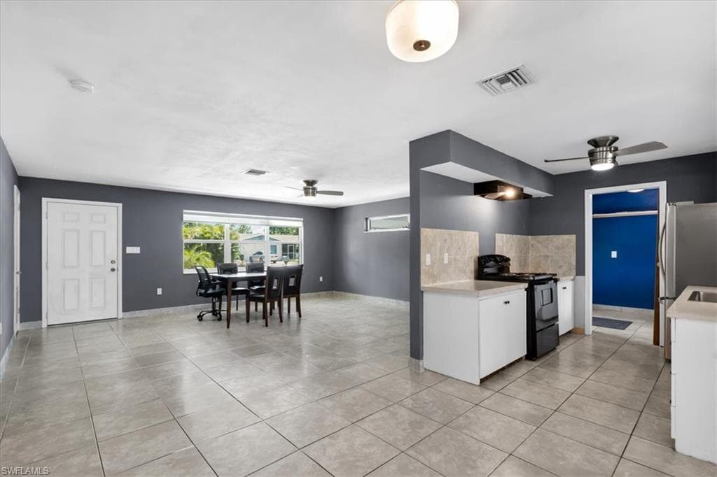 Open-concept living area with tile flooring and a ceiling fan