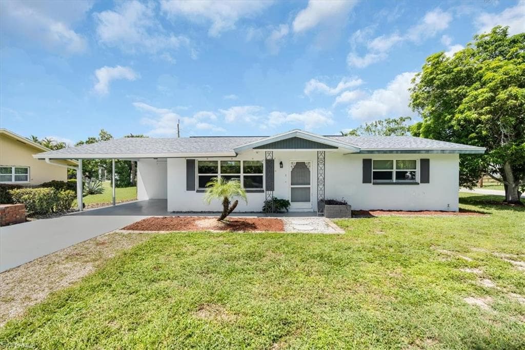 Single-story residence featuring a gray shingle roof, white exterior, and a covered carport