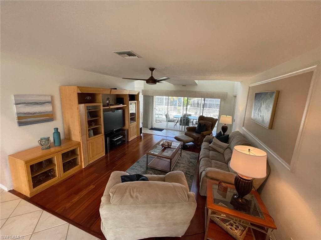 Living area with a ceiling fan and light tile patterned flooring