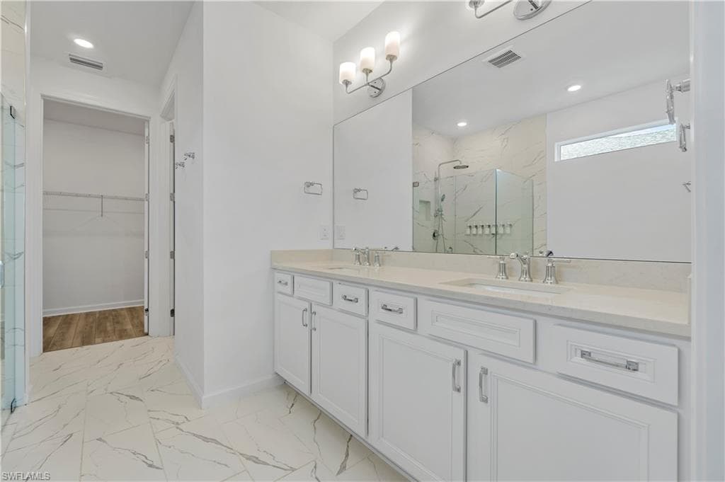 Dual vanity with undermount sinks, stone-finish countertop, and chrome fixtures