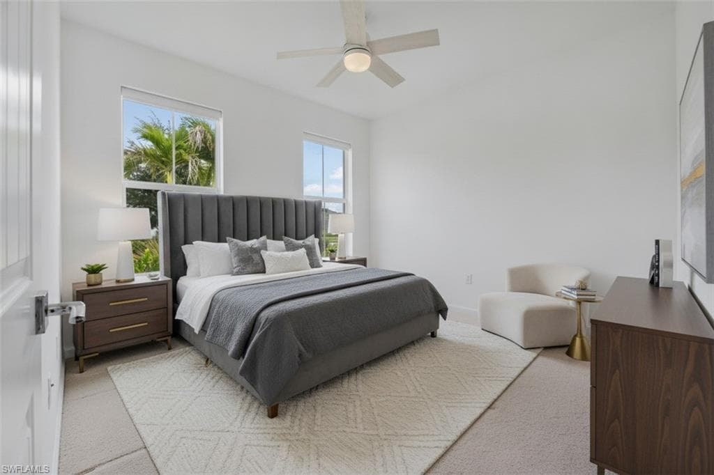 Spacious room with dual windows, overhead ceiling fan, and carpeted flooring