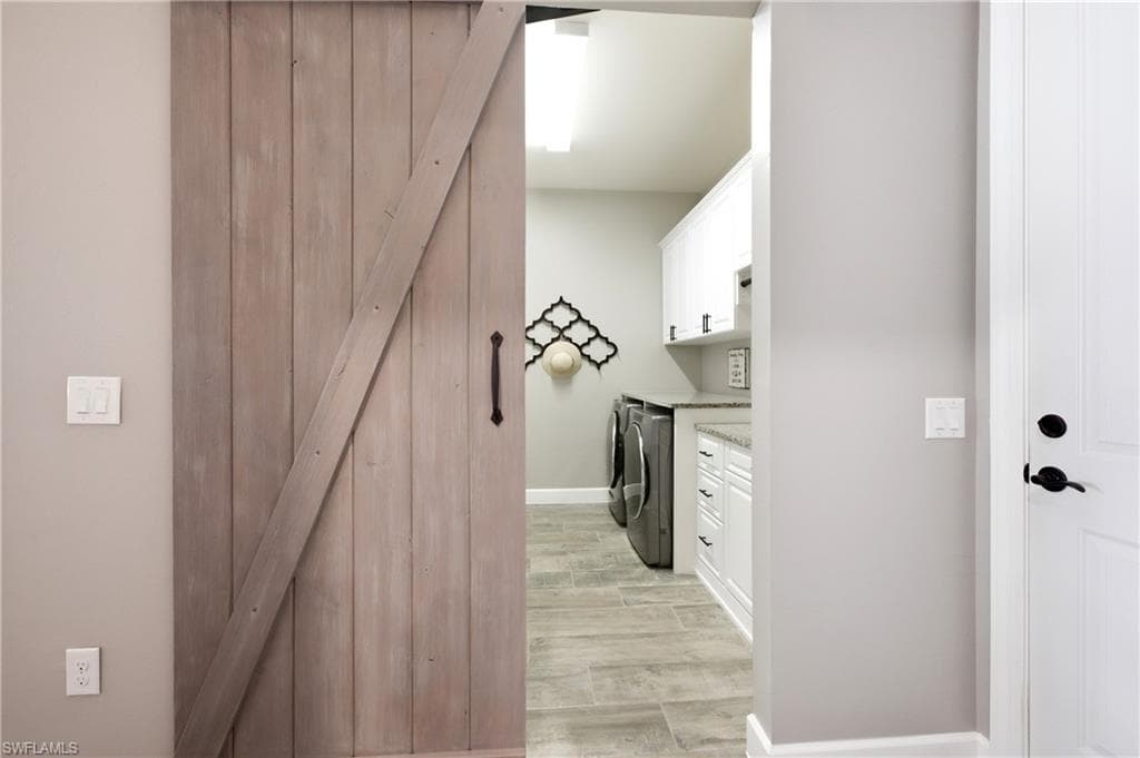 Entrance to laundry room with wood-finish barn door entry