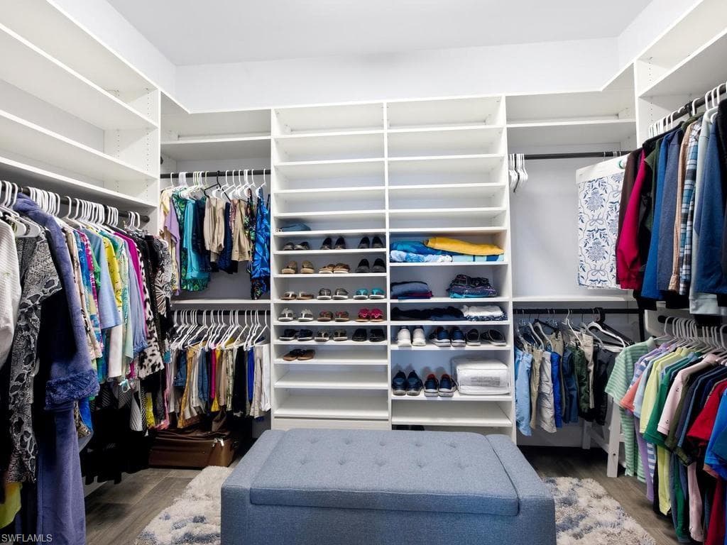 Primary custom closet with extensive shelving, multiple hanging rods