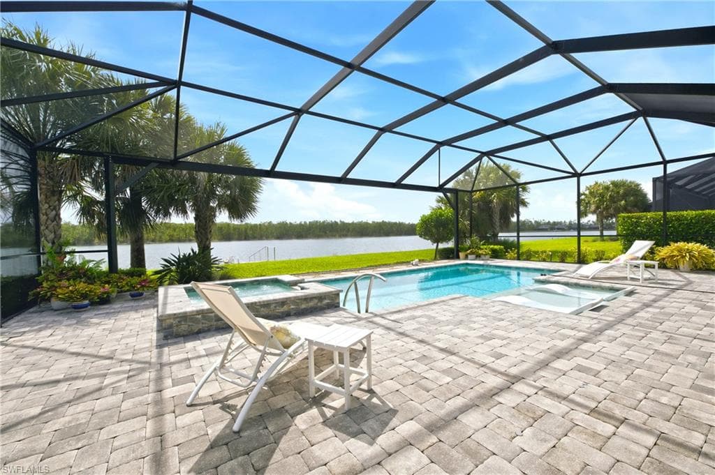 Screened outdoor living area featuring salt-water pool, integrated spa, and expansive paver patio