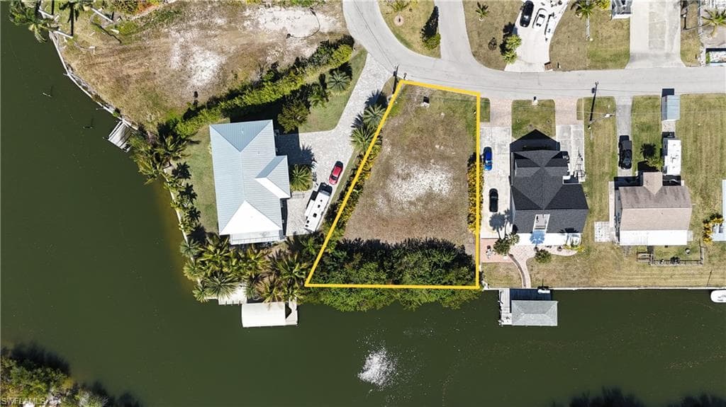 Aerial overview of property's location with a large body of water and property parcel outlined