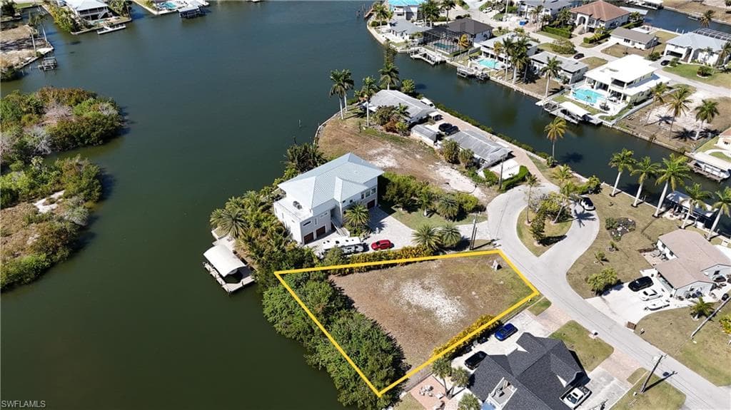 Aerial perspective of suburban area with a nearby body of water and property parcel outlined