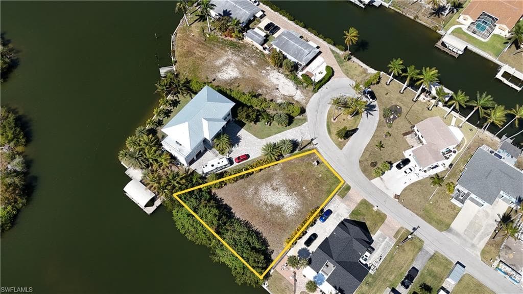 Aerial perspective of suburban area featuring a large body of water and property parcel outlined