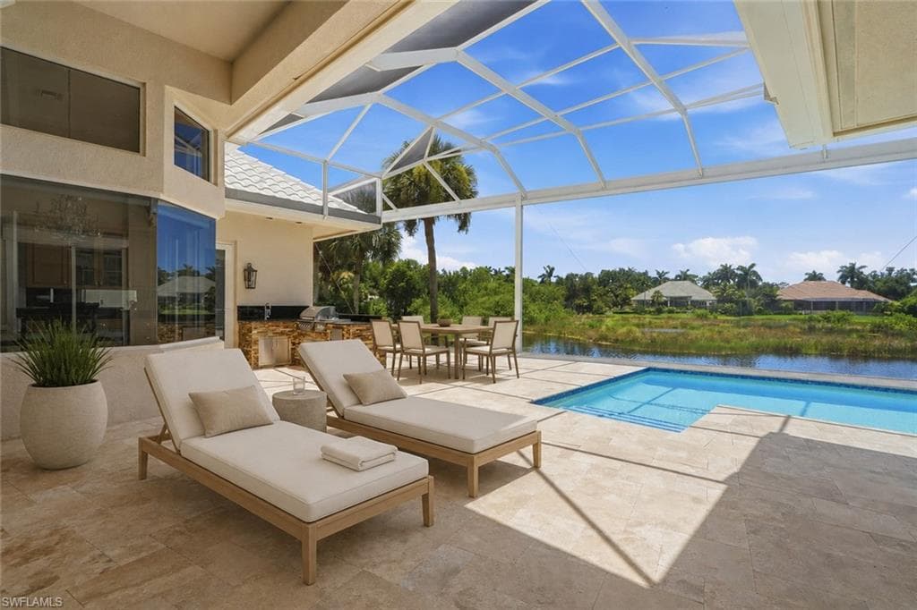 A resort-inspired screened lanai overlooking the pool and peaceful lake beyond.