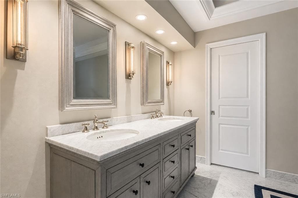 Dual-sink vanity with white quartz countertop and polished nickel faucetry, anchored by a charcoal gray cabinetry base featuring multiple drawers and hardware pulls