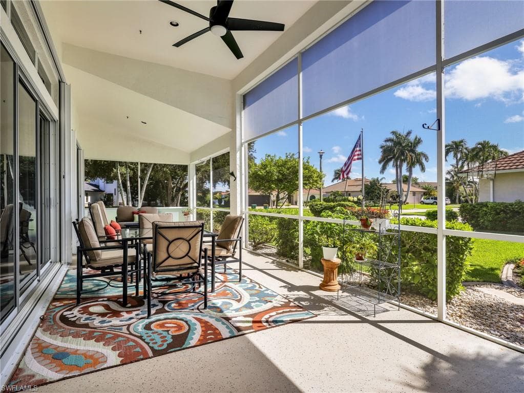 Screened outdoor patio featuring a vaulted ceiling, ceiling fan, and sliding glass doors