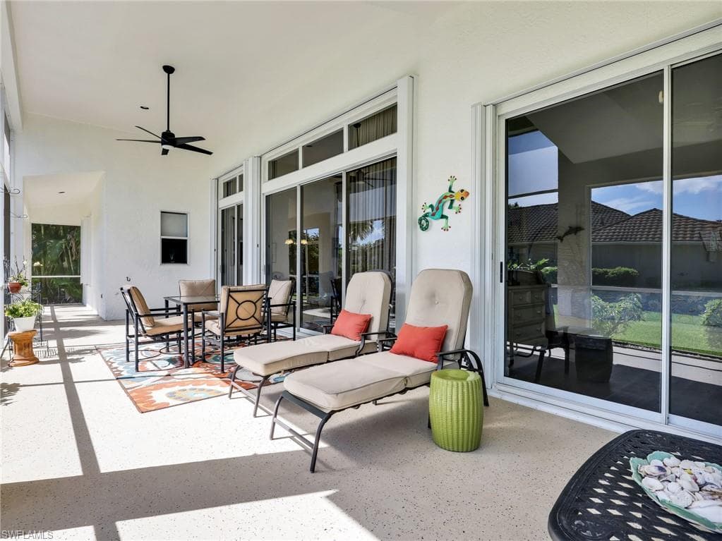 Covered patio with a high ceiling, ceiling fan, and multiple sliding glass doors