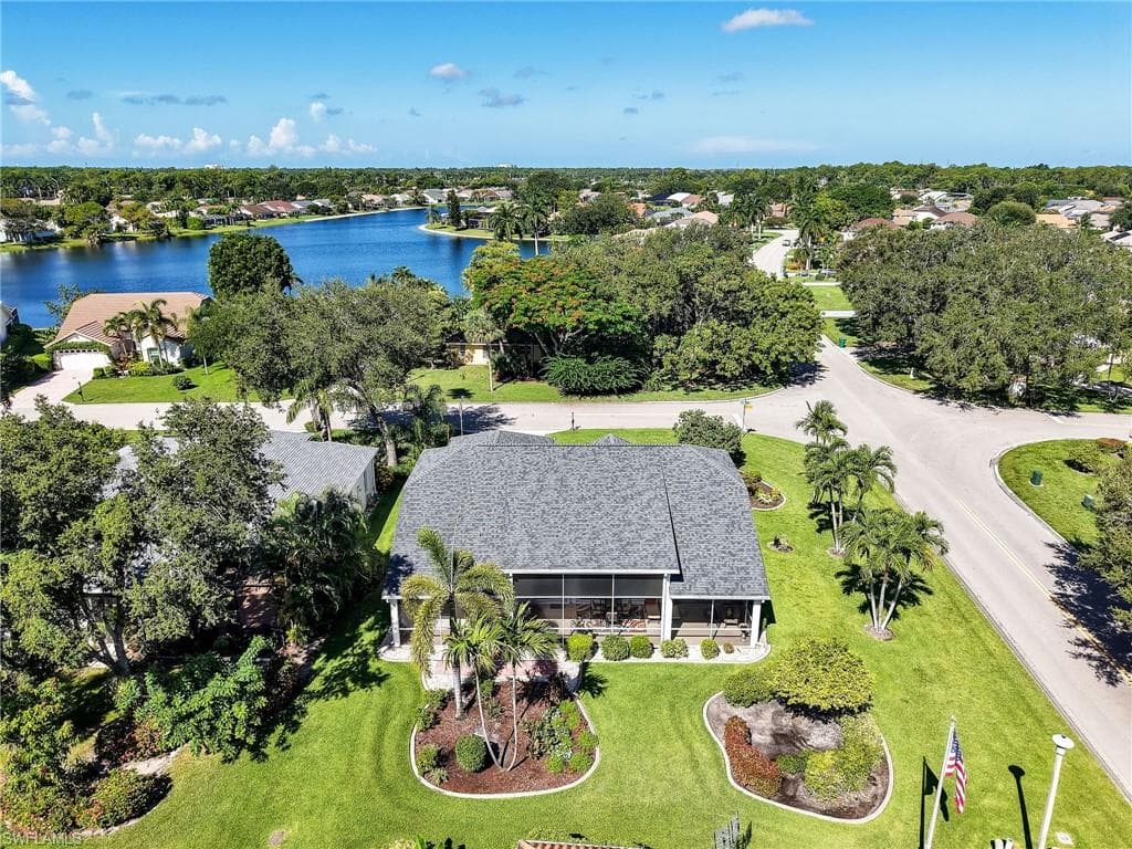 Asphalt shingle roof, screened patio, mature landscaping, palm trees, and established roads