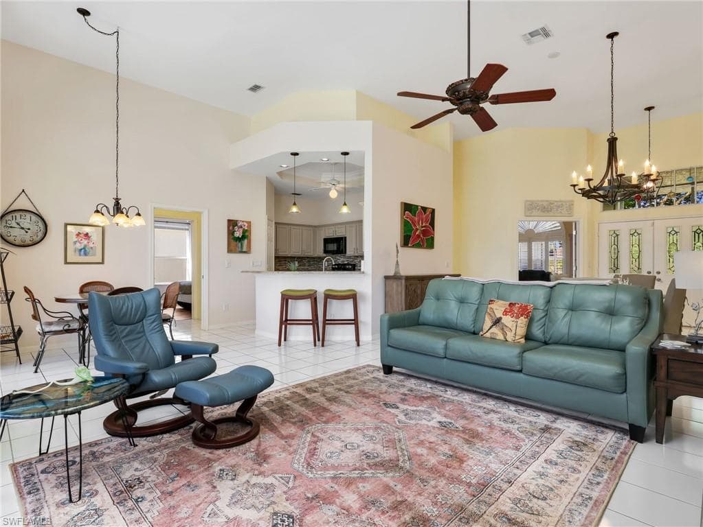 Vaulted ceilings, tiled flooring, chandelier lighting, recessed lighting, and a breakfast bar