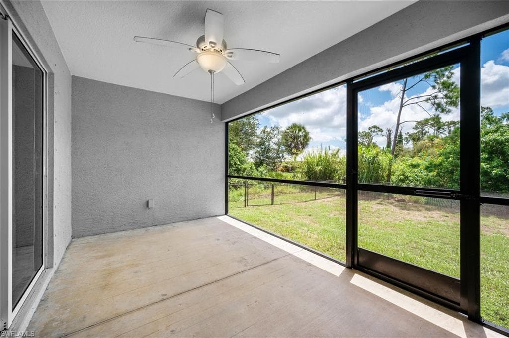 Screened outdoor patio featuring a ceiling fan, concrete flooring, and sliding glass door access