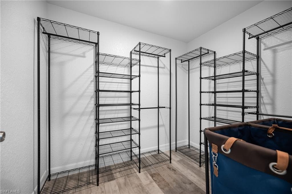 Customizable wire shelving system with hanging rods and wood-finish flooring