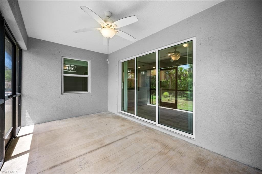 Covered patio with a ceiling fan, concrete flooring, and an exterior window