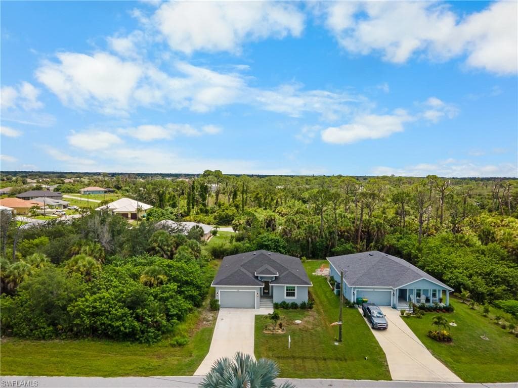 Single-story residence featuring a paved driveway, attached garage, and a covered front entry