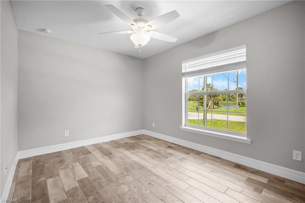 Wood-finish flooring, ceiling fan, white window blinds, and white trim