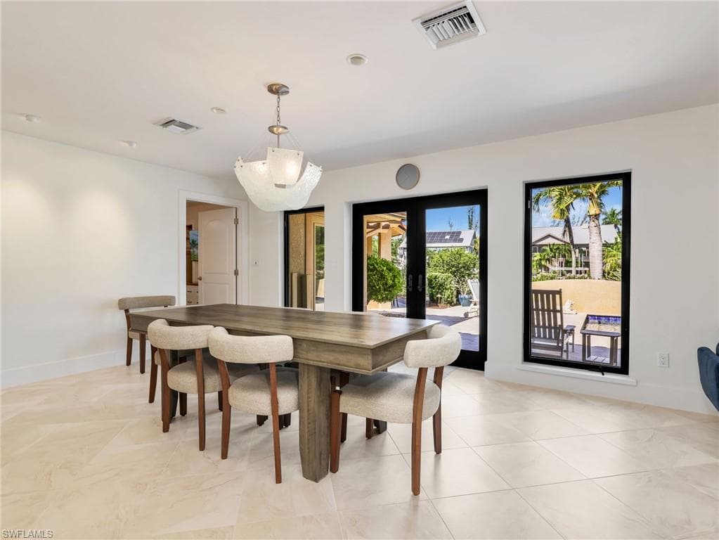 Recessed lighting, a decorative hanging fixture, and tile flooring