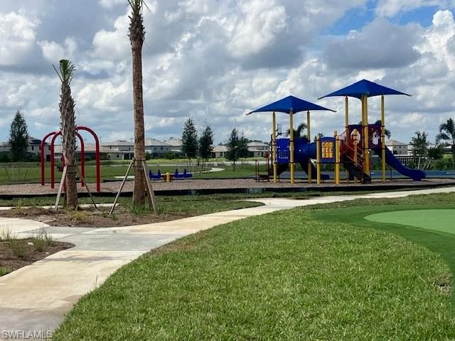 Communal playground with a yard and a putting green