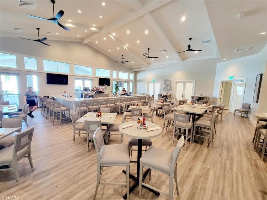 Dining space with ceiling fan, high vaulted ceiling, light wood-type flooring, beam ceiling, and recessed lighting