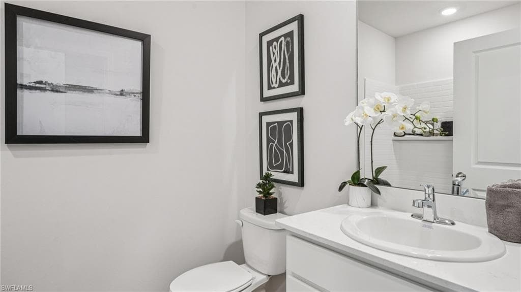 Bathroom vanity featuring an integrated sink, polished chrome faucet, and expansive wall-mounted mirror