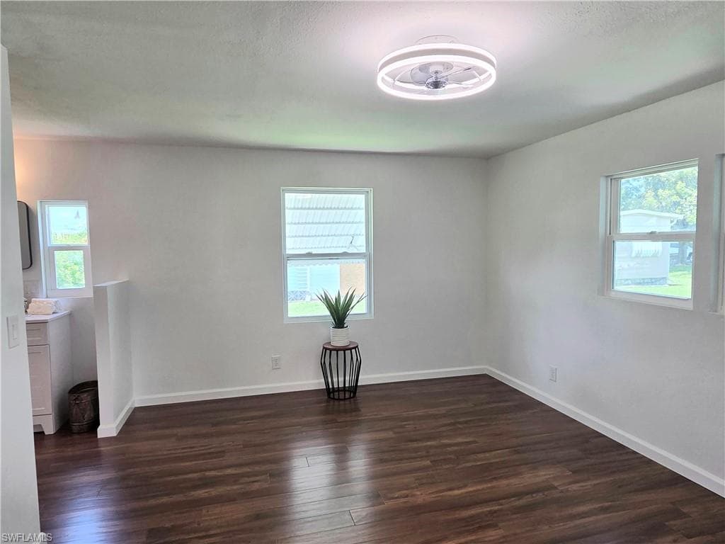 Primary suite with engineered wood flooring and updated light & ceiling fan.