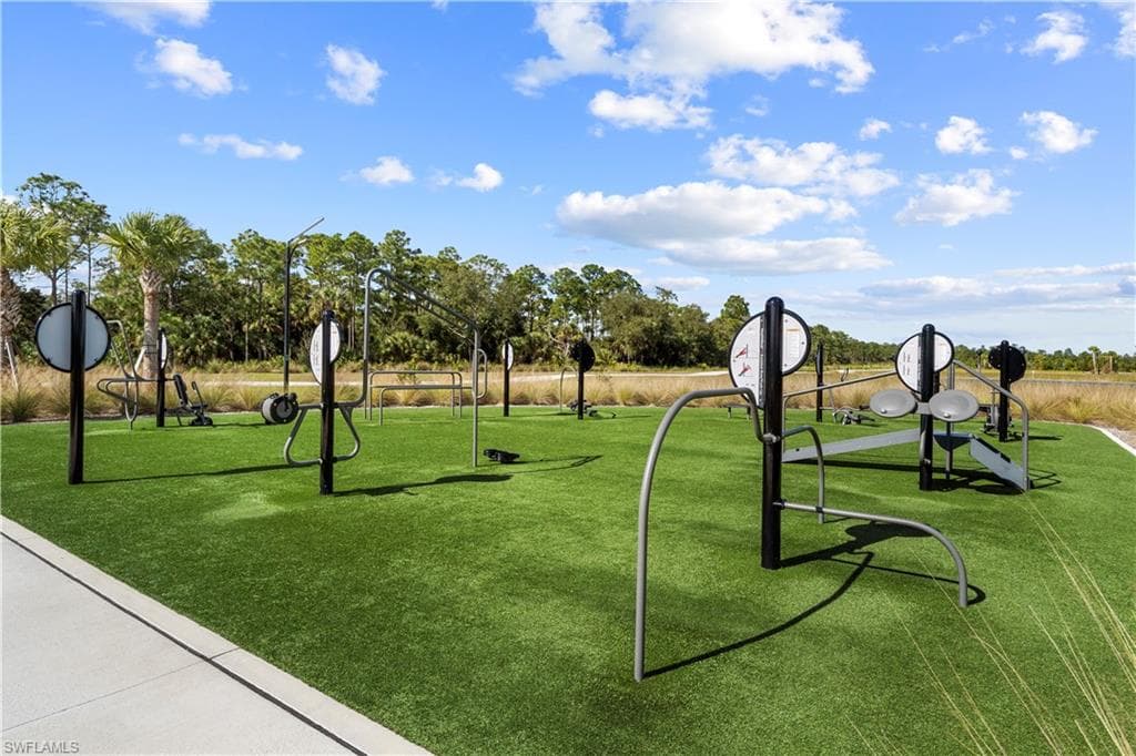 Outdoor fitness equipment on artificial turf with a concrete pathway