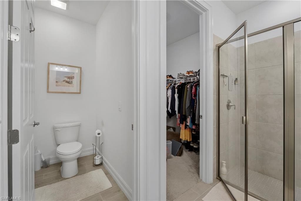 Walk-in shower with clear glass enclosure and tiled walls