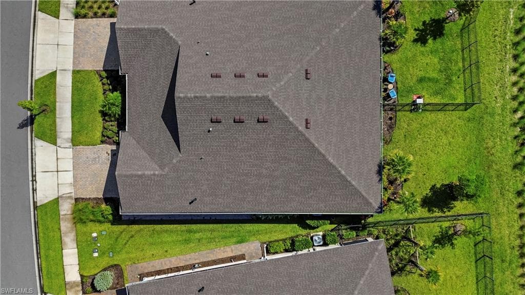 Expansive residential lot featuring a meticulously landscaped yard with mature trees, manicured lawn areas, and defined hardscaping along the perimeter